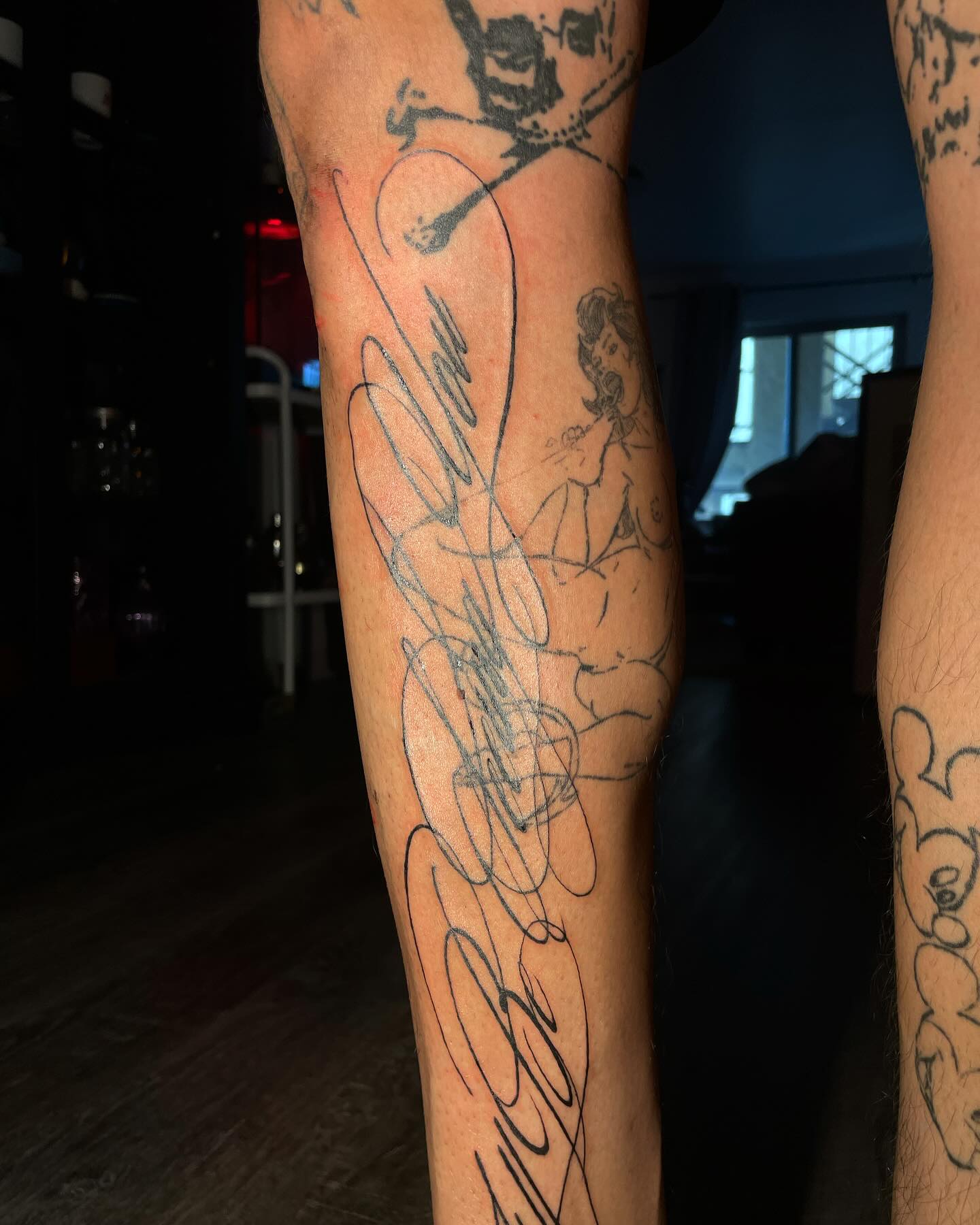 Fine abstract linework tattoos across both arms