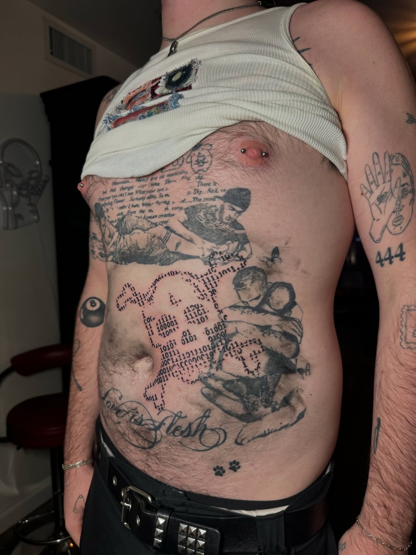 Dense black and gray collage tattoo across a client's side