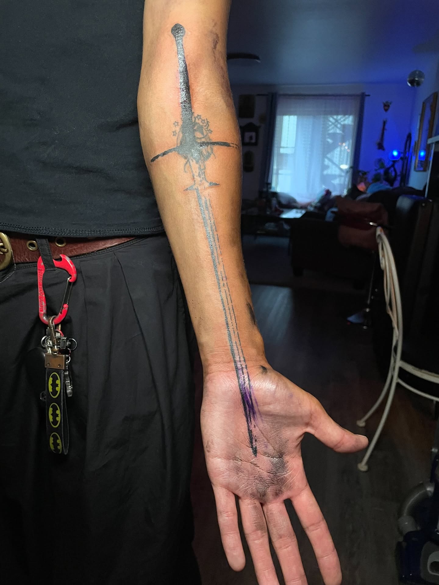Delicate fine-line cross and ornamental marks along a client's forearm