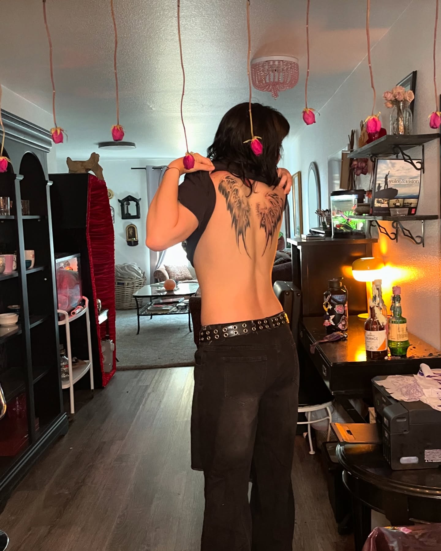 Dark ornamental tattoo centered across a client's upper back