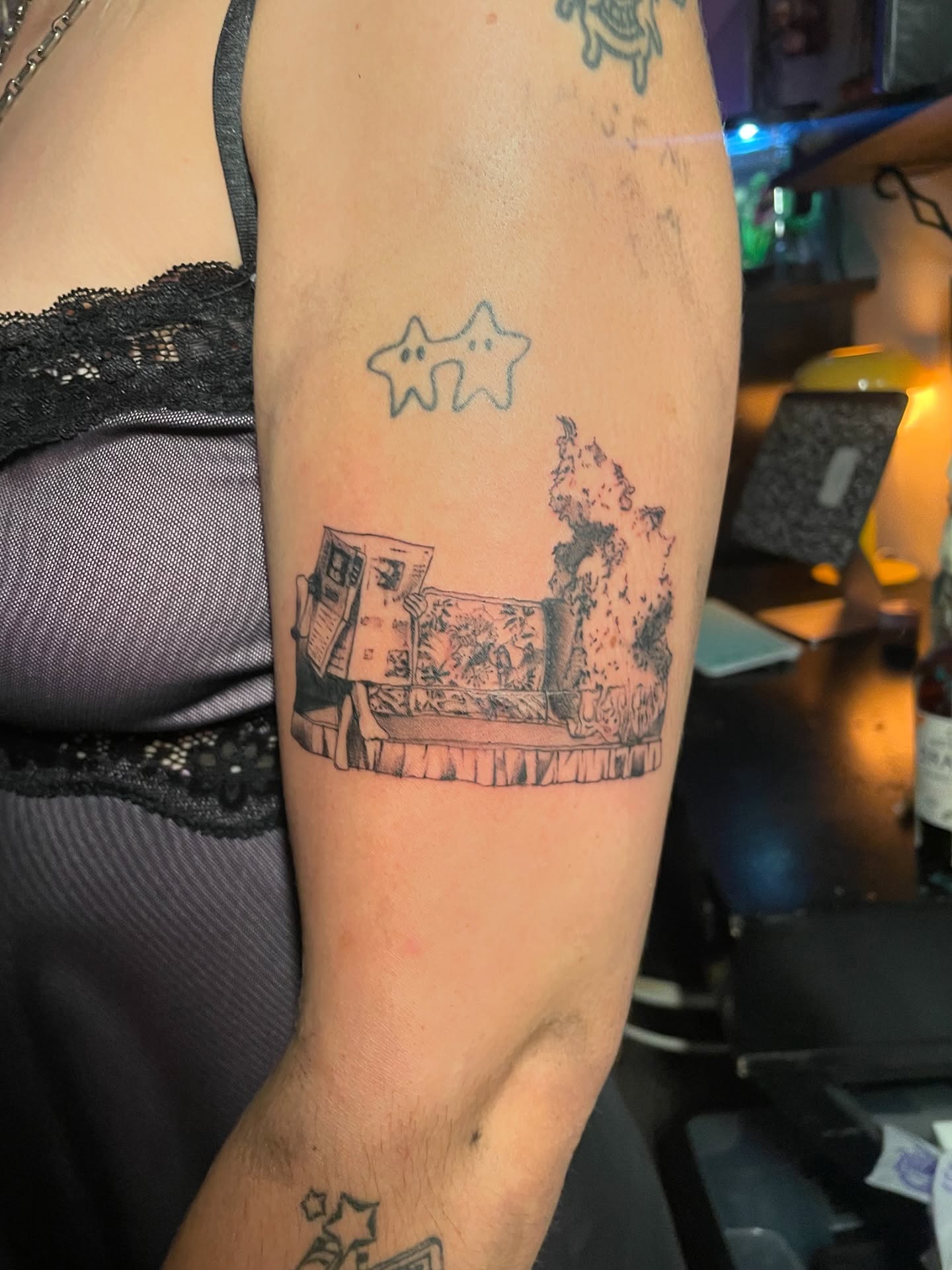 Illustrative patchwork tattoos on a client's upper arm