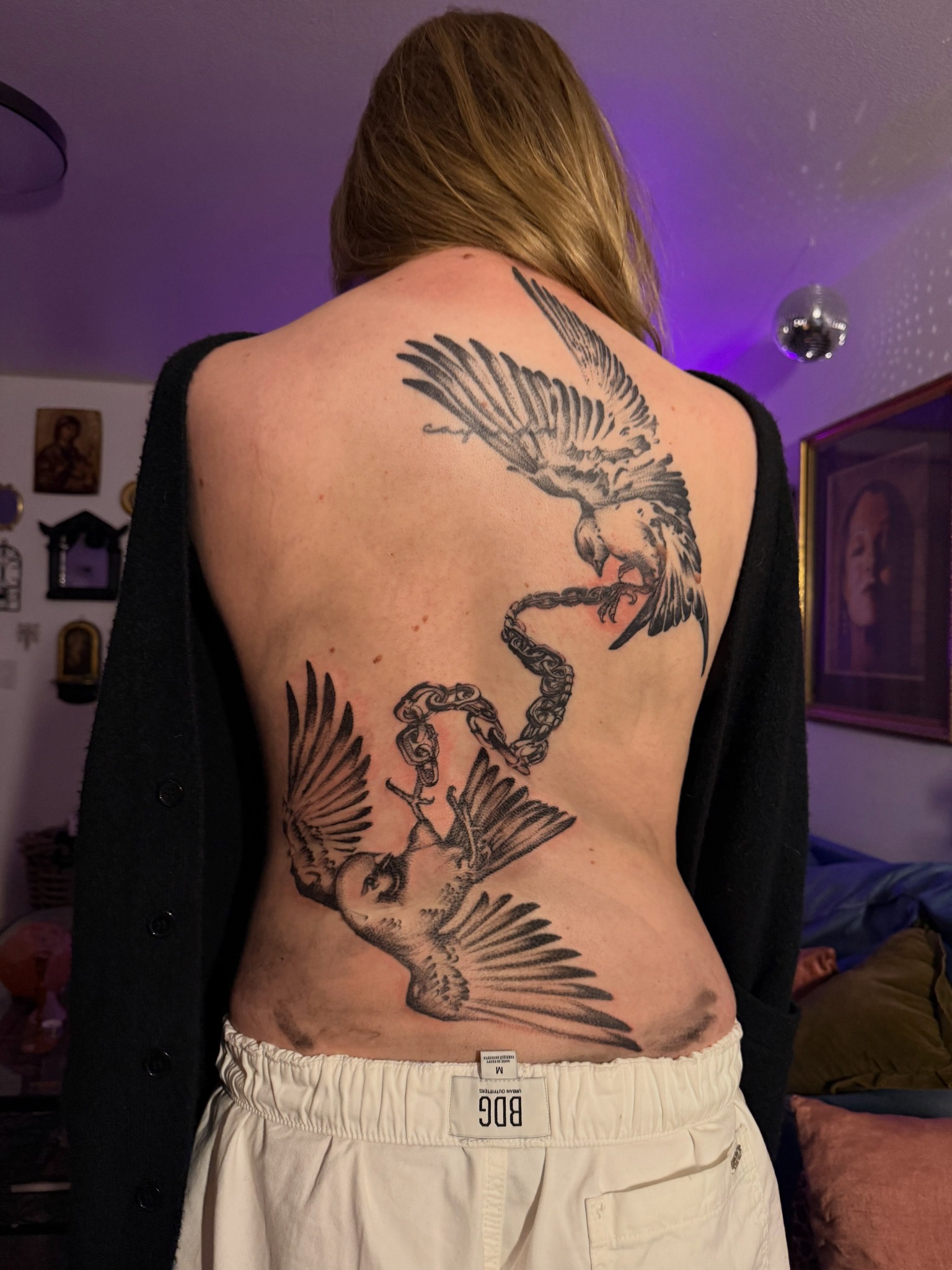 Large blackwork tattoo of winged figures across a client's back